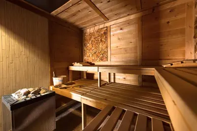 a shirtless man sitting in a bunk bed at Hotel Zirmes in Moena