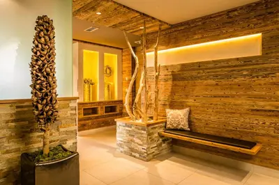 a lobby with a wooden wall with a bench at Hotel Am Sonneck in Lagundo