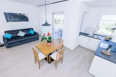 a kitchen and a dining room with a table and chairs at Residence Martinelli in Laives