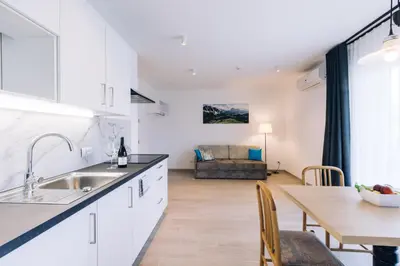 a kitchen and living room with a table and a couch at Residence Martinelli in Laives