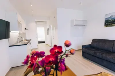 a living room with a couch and a table with flowers at Residence Martinelli in Laives