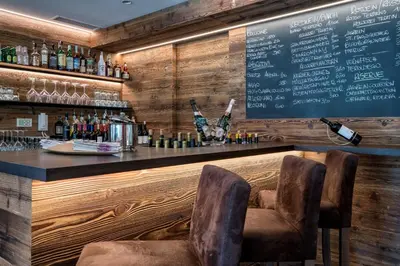 a bar with two chairs and a menu on the wall at Residence Martinelli in Laives