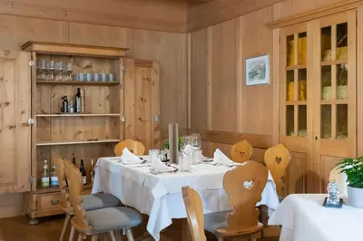 a dining room with a white table and chairs at Hotel Teutschhaus in Cortina Sulla Strada Del Vino