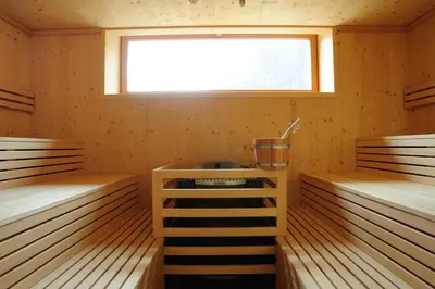 a wooden sauna with two beds and a window at Hotel Teutschhaus in Cortina Sulla Strada Del Vino