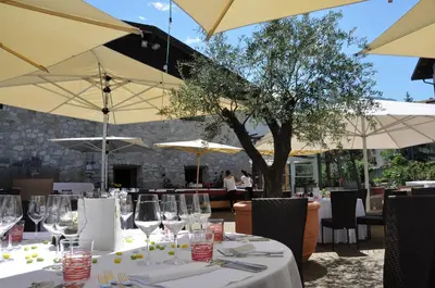 a table with wine glasses and umbrellas at a restaurant at Hotel Teutschhaus in Cortina Sulla Strada Del Vino