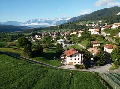 a village in a valley with mountains in the background at B&B RAINA in Castelfondo