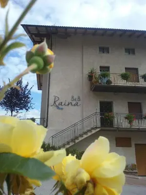 a building with a yellow flower in front of it at B&B RAINA in Castelfondo