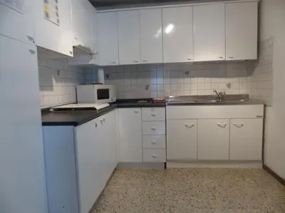 a small kitchen with white cabinets and a microwave at Mountain in Alleghe
