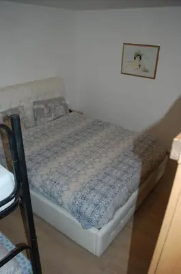 a bed in a bedroom with a picture on the wall at Mountain in Alleghe