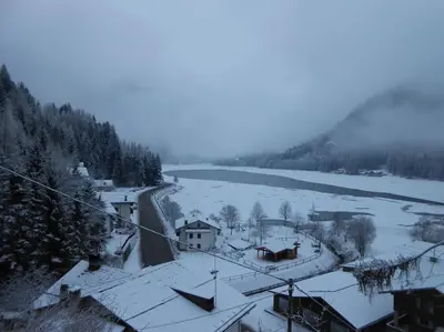 a town with snow covered roofs and a river at Mountain in Alleghe