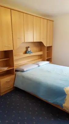 a bedroom with a bed with blue pillows on it at Cèsa Chri e Sofì in Campitello di Fassa