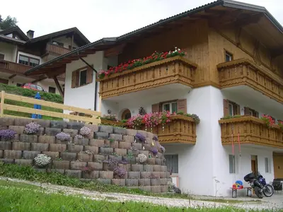 a building with snow on the ground in front of it at Cèsa Chri e Sofì in Campitello di Fassa