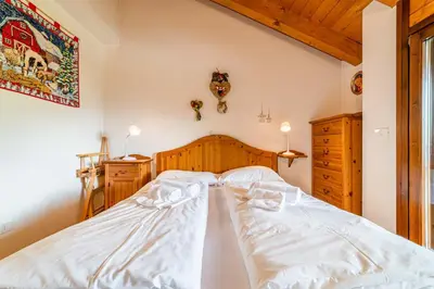 a large white bed with two pillows on it at Dolomites Dream Arabba in Livinallongo del Col di Lana
