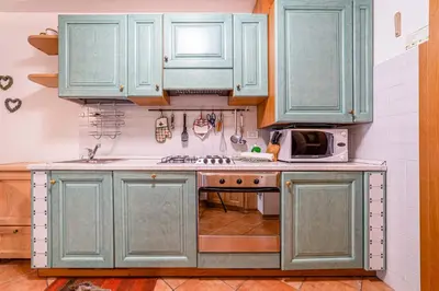 a kitchen with blue cabinets and a microwave at Dolomites Dream Arabba in Livinallongo del Col di Lana