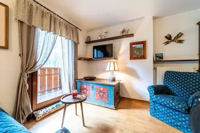 a living room with a blue couch and a window at Dolomites Dream Arabba in Livinallongo del Col di Lana