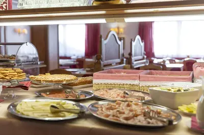 a table with many plates of food on it at Hotel Cristallo in Canazei