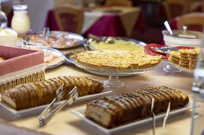 a table topped with different types of food on plates at Hotel Cristallo in Canazei