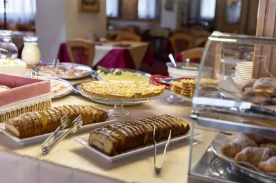a table topped with trays of food and pastries at Hotel Cristallo in Canazei
