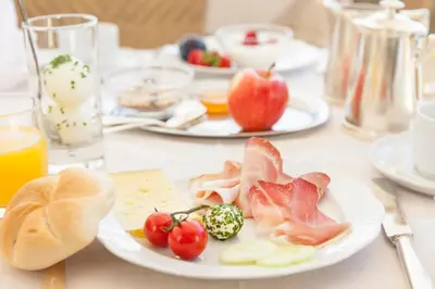 a table with plates of food on a table at Hotel Bemelmans-Post in Collalbo