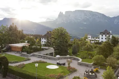 a view of a garden with mountains in the background at Hotel Bemelmans-Post in Collalbo