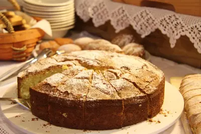 a cake sitting on a plate on a table at Hotel Fonte Dei Veli in Panchia