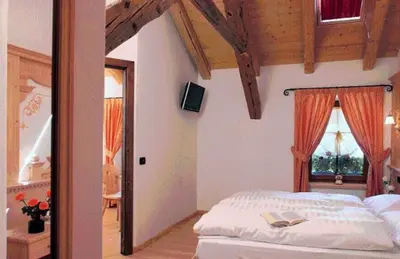 a bedroom with a white bed and a window at Hotel Fonte Dei Veli in Panchia