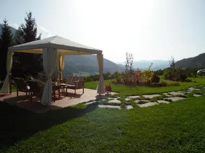a gazebo with a table and chairs in a yard at Hotel Fonte Dei Veli in Panchia