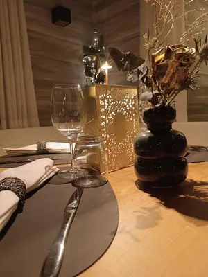 a table with two wine glasses and a candle on it at Hotel Stella in Moena
