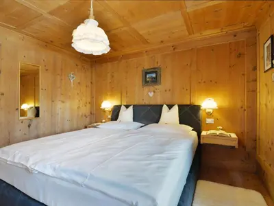 a bedroom with a large bed in a wooden room at Apartment Luca by Interhome in Ortisei