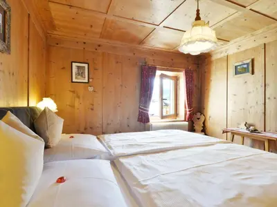a bedroom with a large bed with a wooden ceiling at Apartment Luca by Interhome in Ortisei