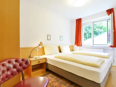 a bedroom with a bed and a nightstand with two lamps at Apartment Illyria by Interhome in Ortisei