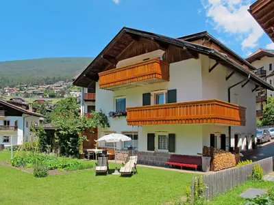 a house in the snow with mountains in the background at Apartment Demetz by Interhome in Ortisei