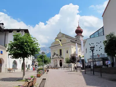 a building with a clock tower on a street at Apartment Demetz by Interhome in Ortisei