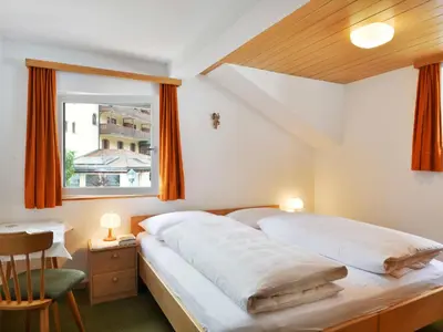 a bedroom with a large bed and a window at Apartment Demetz by Interhome in Ortisei