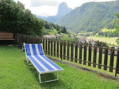 a blue chair sitting in the grass in a yard at Apartment Mastle by Interhome in Ortisei