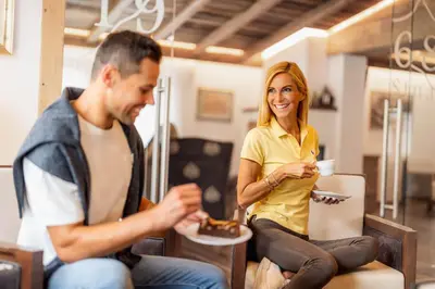 a man and woman eating food in a room at Renè Dolomites Boutique Hotel in Pozza di Fassa