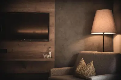 a man laying on a bed with his feet on a wall at Hotel Christof in Monguelfo