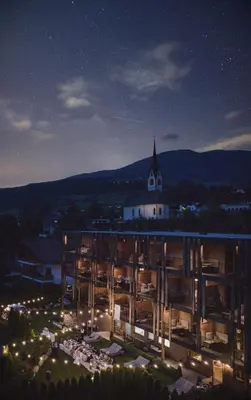 a large building at night with a church at Hotel Christof in Monguelfo