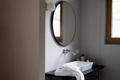 a bathroom with a sink and a mirror at Hotel Schwarzschmied, a Member of Design Hotels in Lana
