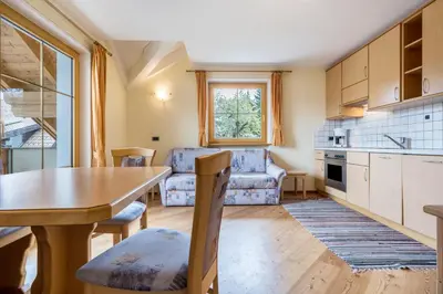a kitchen and living room with a table and a dining room at Residence Oberhauser in Valdaora