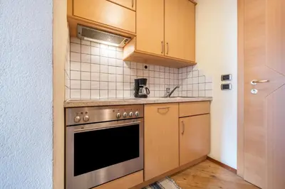 a kitchen with wooden cabinets and a stainless steel oven at Residence Oberhauser in Valdaora
