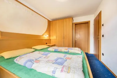 a bedroom with a bed with a wooden head board at Residence Oberhauser in Valdaora