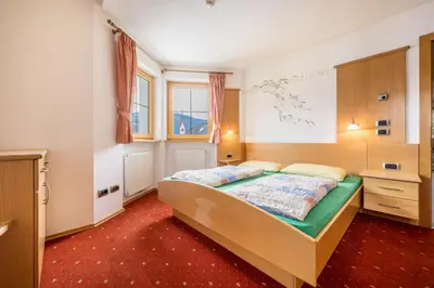 a bedroom with a bed and a desk at Residence Oberhauser in Valdaora