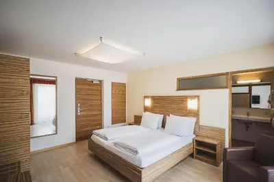 a hotel room with a bed and a couch at Hotel Brötz in Rasùn di Sotto