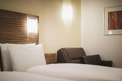 a hotel room with a bed and a chair at Hotel Brötz in Rasùn di Sotto
