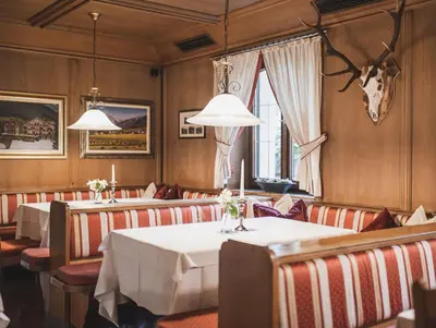 a dining room with tables and chairs and lights at Hotel Brötz in Rasùn di Sotto