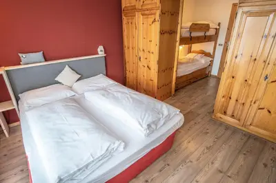 a bedroom with a bed and a couch in a room at Hotel Resort Veronza in Cavalese