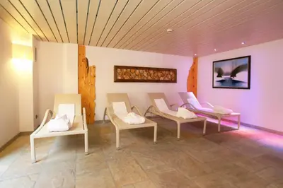 a wooden sauna with a bucket in the middle at Hotel Resort Al Sole in Canazei