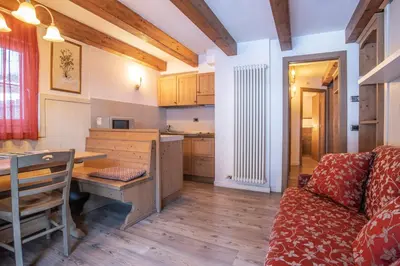 a bedroom with a bed and a table with flowers on it at Hotel Resort Al Sole in Canazei