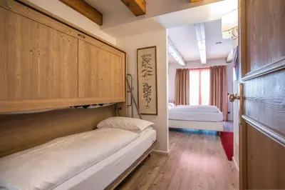 a small room with two beds and a door at Hotel Resort Al Sole in Canazei
